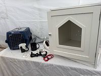 Overall view showing cat house, pet carrier, mugs, planter, collars, pin