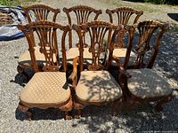 Front view of all six matching carved wood chairs