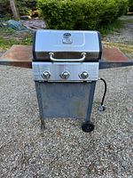 Front view of Blue Rhino grill showing overall design, three knobs, side shelves and wheels