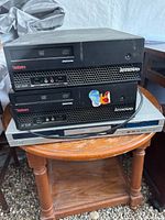 Front view of two Lenovo ThinkCentre desktops stacked on silver DVD player