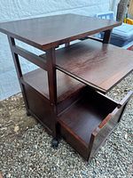 Front angled view showing top, keyboard tray, open file drawer and casters