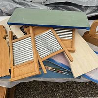 Stack of unfinished wood washboards, plaque, canvases and paintbrushes