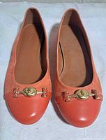 Top view of both flats showing suede and leather two-tone design with gold hardware