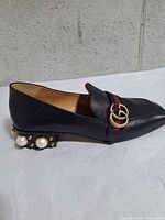 Right side view of right shoe showing pearl-studded heel, web stripe and hardware