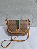 Front view showing GG monogram, web stripe, flap, strap
