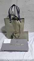 Tote bag front with pouch, dust bag and care card visible