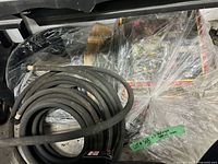 Coiled black soaker hose with plastic female connector visible