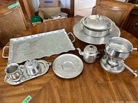 Full set displayed on table showing all eight hammered aluminum pieces