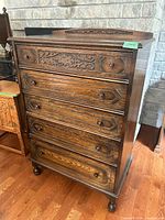 Front view of solid oak dresser showing five drawers and carved details