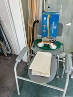 Overall lot showing shower chair, grab handle, bath rail box, crutches, cane and underpads