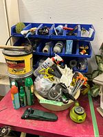 Overall view of lot on workbench with organizer, Quikrete tub, bowl of safety gear, timer, sheath