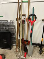 Front view of all garden tools leaning against wall