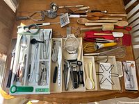 Overview of all kitchen utensils and gadgets spread in drawer organizers on table