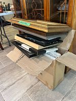 stack of assorted frames in open carton