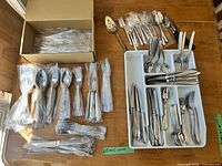 Full lot view showing boxed and sorted flatware bundles