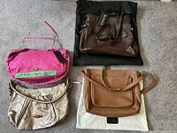 All four handbags laid out: Bodhi brown, Elliott Lucca pink, Elliott Lucca gold, cognac tote