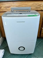 Front view of Electrolux white dehumidifier showing water tank section and handle
