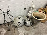 Group view of urn, peacock statue, metal stand and three cutout spheres
