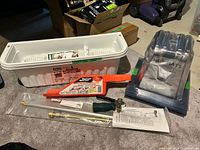 Lot overview showing planter, gutter cleaner, weeder parts, HotHats package