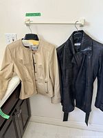 Front view of both leather jackets on hangers