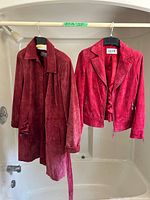 Both red suede outerwear pieces hanging to show overall condition and style