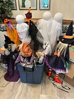 Full lot view showing ghosts, witches, pumpkins, storage tote and miscellaneous contents