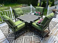 Full patio set showing table, four chairs, cushions, pillows, rug