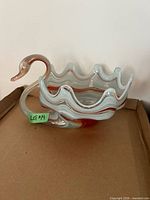 Side view showing swan neck handle, ruffled rim, color pattern