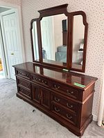 Front view of dresser showing drawers, cabinet, and attached three-panel mirror