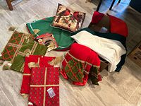 Overview of tree skirts, pillow, placemats, runner and linens on floor