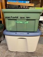 Two stacked plastic storage tubs labeled holiday planter decor items