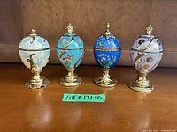 All four decorative eggs on stands closed, front view