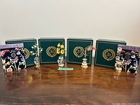 All four bud vases displayed with their green JR boxes and booklets