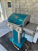 Full view of teal Kenmore gas grill closed