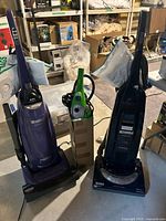 Purple and dark blue Kenmore upright vacuums with green H2O Mop between