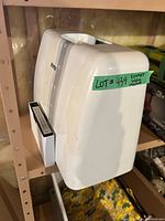 White hard plastic carrying case on shelf