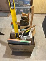 Overall view of box with level, saws, hammer, assorted tools