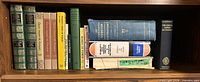 Full shelf view showing all fifteen books upright and stacked