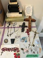 Full lot overview showing books stack, crucifixes, rosaries, medals