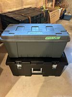Gray Plano storage trunk stacked on black Sterilite trunk, closed lids visible