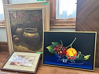 All three framed still-life paintings standing together