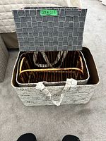 View of large cream script bin containing bamboo magazine rack and gray woven lidded box