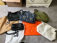 Group shot of all five handbags with dust bags