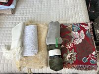 Six throws lined up on mattress