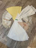 All seven folded round linens displayed fan-style on floor