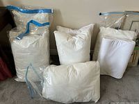 Group of pillow inserts in plastic storage bags and loose