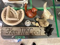 Overview showing plaque, bird figurines, dogs, stone baskets, tealight