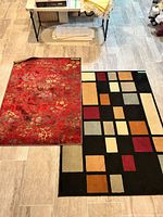 Both rugs laid out on floor showing patterns and relative sizes