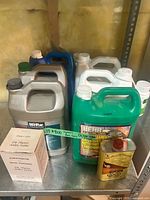 Overview of multiple BEHR, ACTIVOX jugs, Restore-A-Finish can and Old Masters boxes on shelf