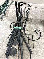 Pile of black metal shepherd hooks, stakes and bases